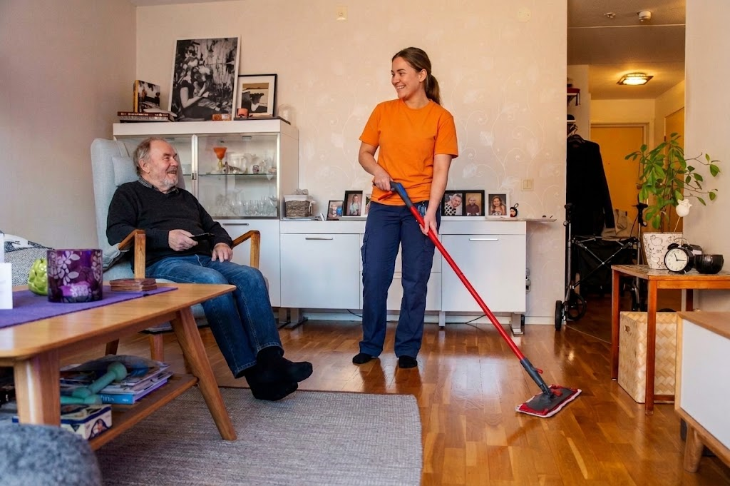 Kvillestäds lokalvårdare moppar ett hem där en äldre person sitter i fåtöljen